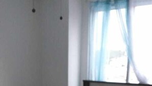 A bedroom with a bed, a headboard, a window with curtains, and a ceiling fan. - Apartamento en Altos de Santa Maria Condado del Rey, Imajo (San Miguelito)