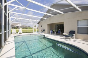 A swimming pool with a covered patio area, outdoor furniture, and a view of the neighborhood. - Sundowners by VillaDirect (Davenport)