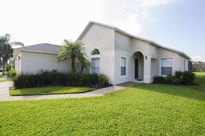 A single-story house with a flat roof, a front entrance with a door, and a small porch. - Sundowners by VillaDirect (Davenport)