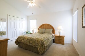 A bedroom with a bed, nightstands, a ceiling fan, and a window. - Sundowners by VillaDirect (Davenport)