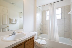 A bathroom with a sink, toilet, and bathtub. - Sundowners by VillaDirect (Davenport)