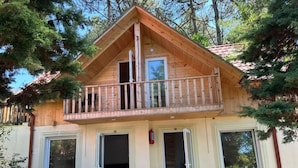 A wooden cabin with a balcony, a staircase, and a door leading to a garage. - Kolkhida Resort & Spa (Ureki)