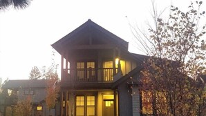 A two-story house with a balcony, a front porch, and a driveway. - Bluebird Day - Wild River Getaway, Escape to this cozy 2-bedroom retreat in Bend, OR. (Bend)