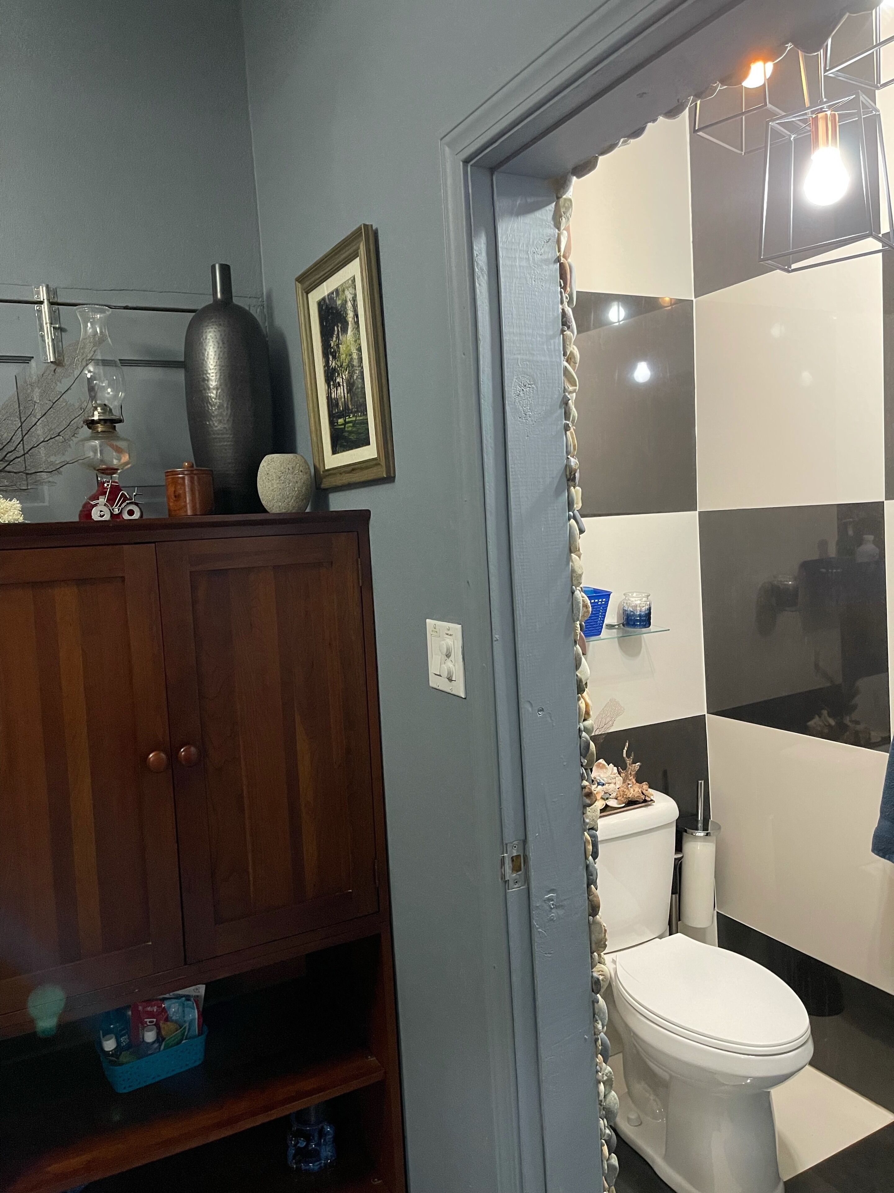 A bathroom with a toilet, a sink, and a cabinet.