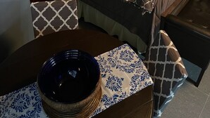 Ein Schlafzimmer mit Bett, Nachttischen, einem Schminktisch und einem Fenster mit Vorhängen.