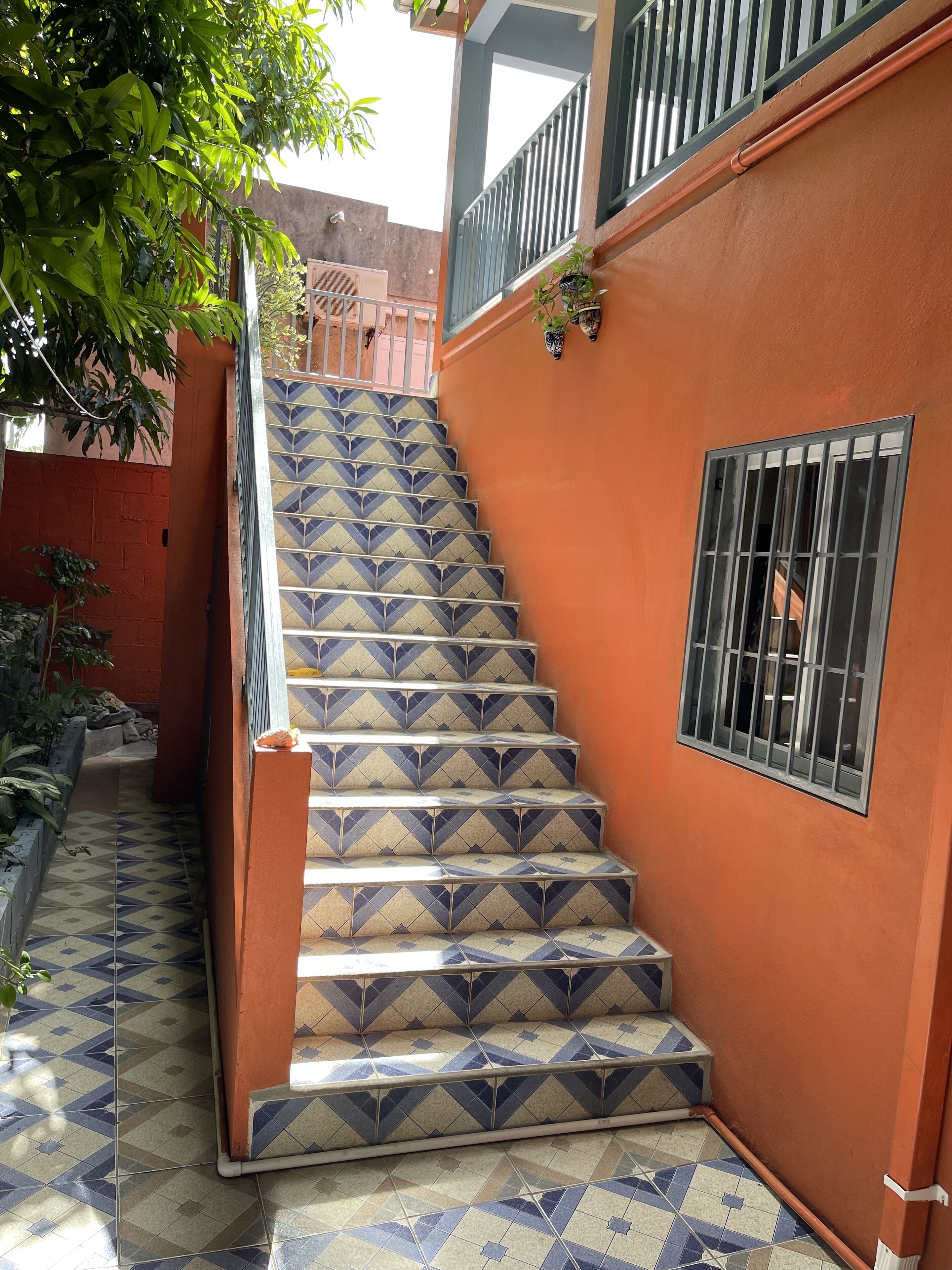 A staircase with patterned tiles leading to a balcony.