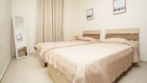 Un dormitorio con dos camas, un espejo y dos cuadros en la pared.