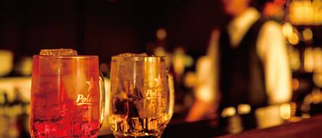 Dos vasos con la palabra "Poles" escritos, sobre una barra de bar.