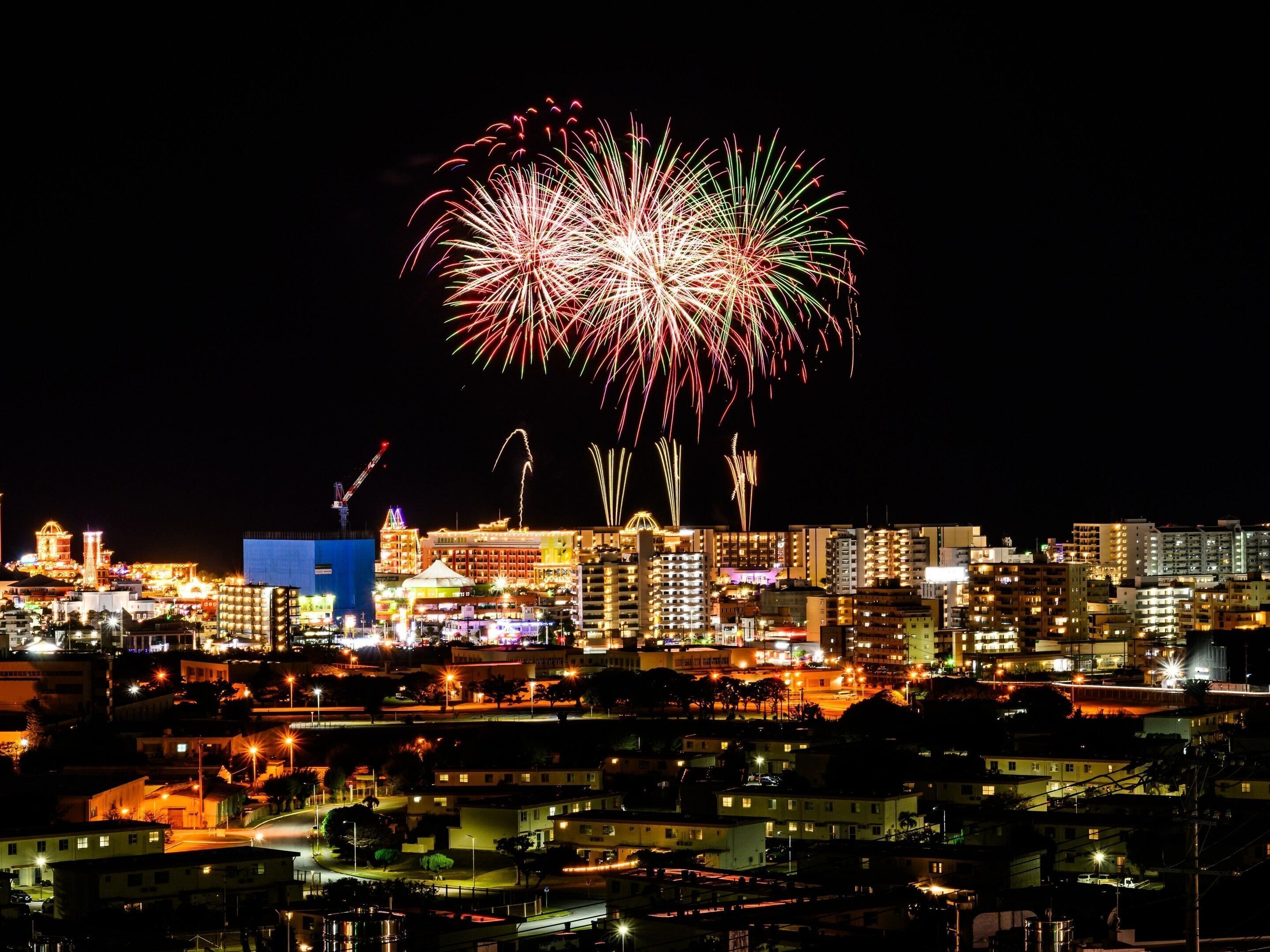 Un paisaje urbano nocturno con fuegos artificiales en el cielo.