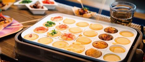 A breakfast setup with a variety of dishes including pancakes, omelets, and a drink.
