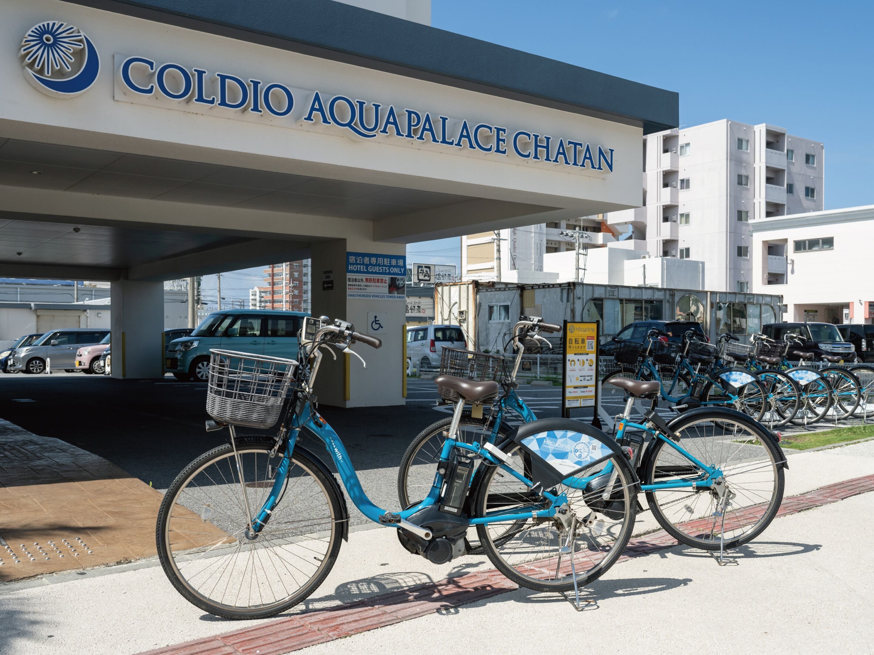 A bike rental station with bicycles and a sign for Coldio Aquapalace Chatan.