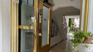 A hotel entrance with a glass door, a staircase, and a potted plant. - Belka Golf Residence (Serik)