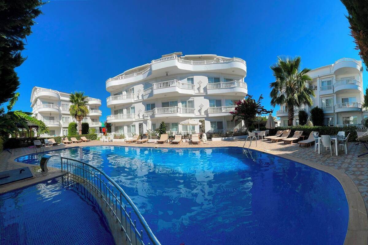 A resort with a swimming pool, multiple balconies, and outdoor seating areas.