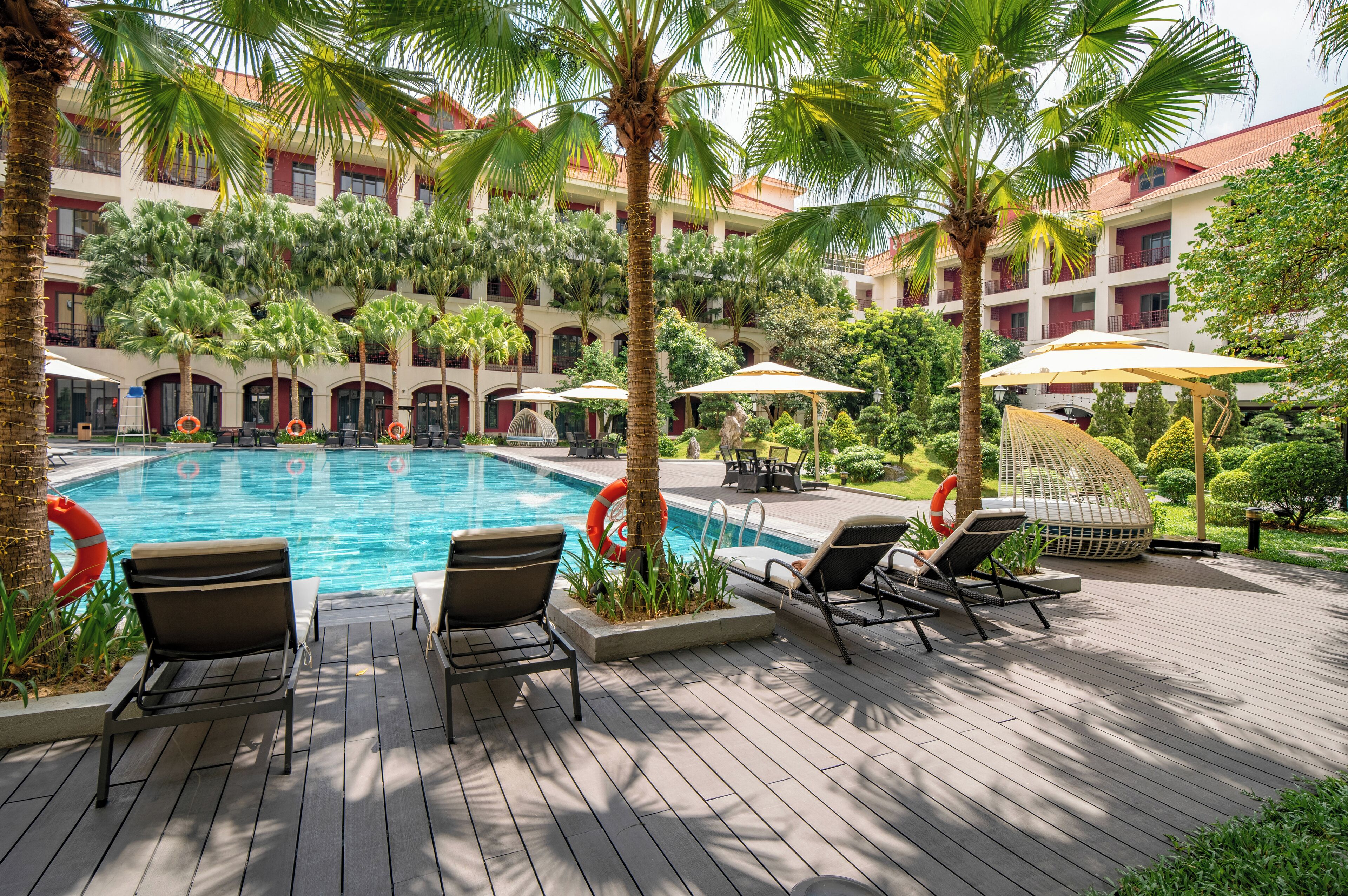 Una piscina al aire libre, sillones reclinables de piscina