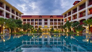 A large hotel with a central pool, multiple balconies, and lush landscaping. - Senna Hue Hotel (Hue)