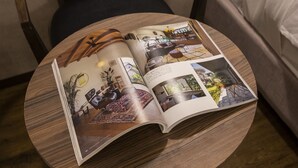 An open magazine on a round wooden table, featuring interior design and home decor. - Mr.KINJO in Rycom Kitanakagusuku (Kitanakagusuku)