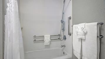 A bathroom with a bathtub, a shower, and a towel rack.