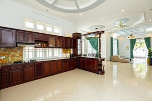 Een koelkast, een waterkoker, kookgerei, borden en bestek