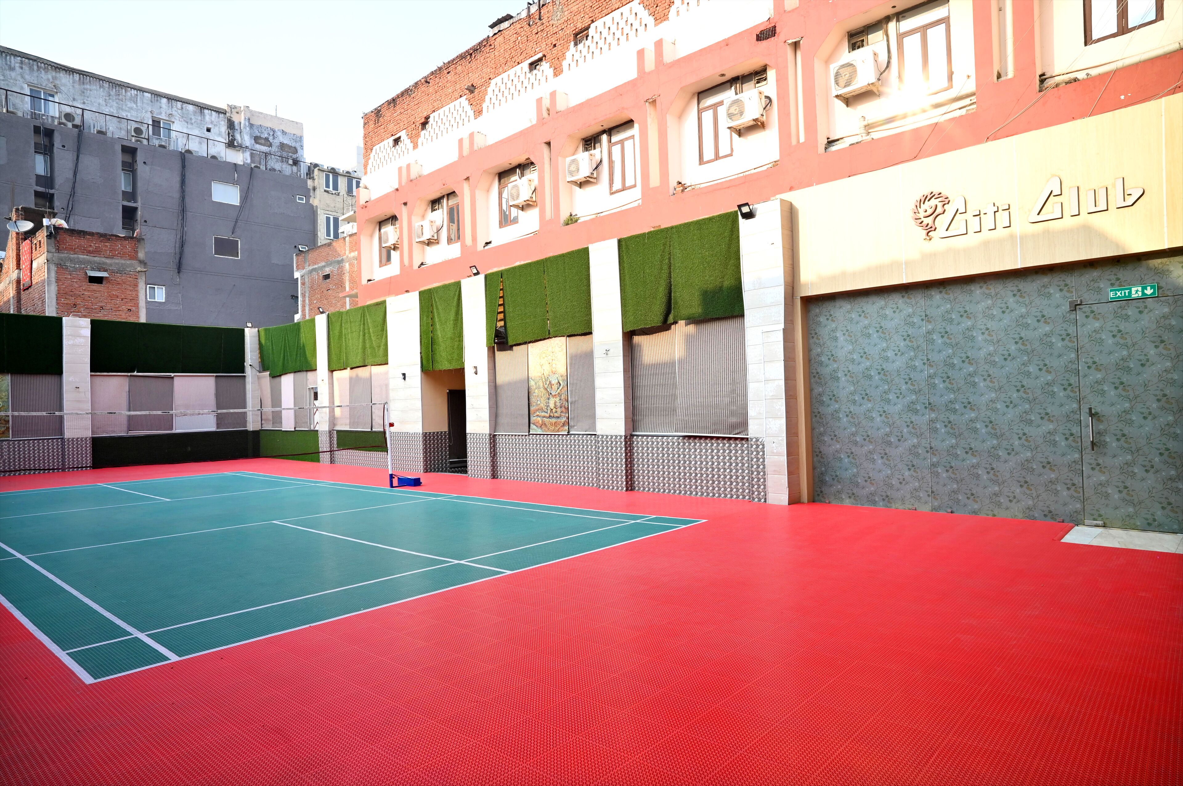 Una cancha de tenis al aire libre junto a un edificio con un letrero que dice "2nd Club".