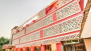 A multi-story building with intricate latticework on the facade and potted plants along the walkway. - Citi Club (Kanpur)