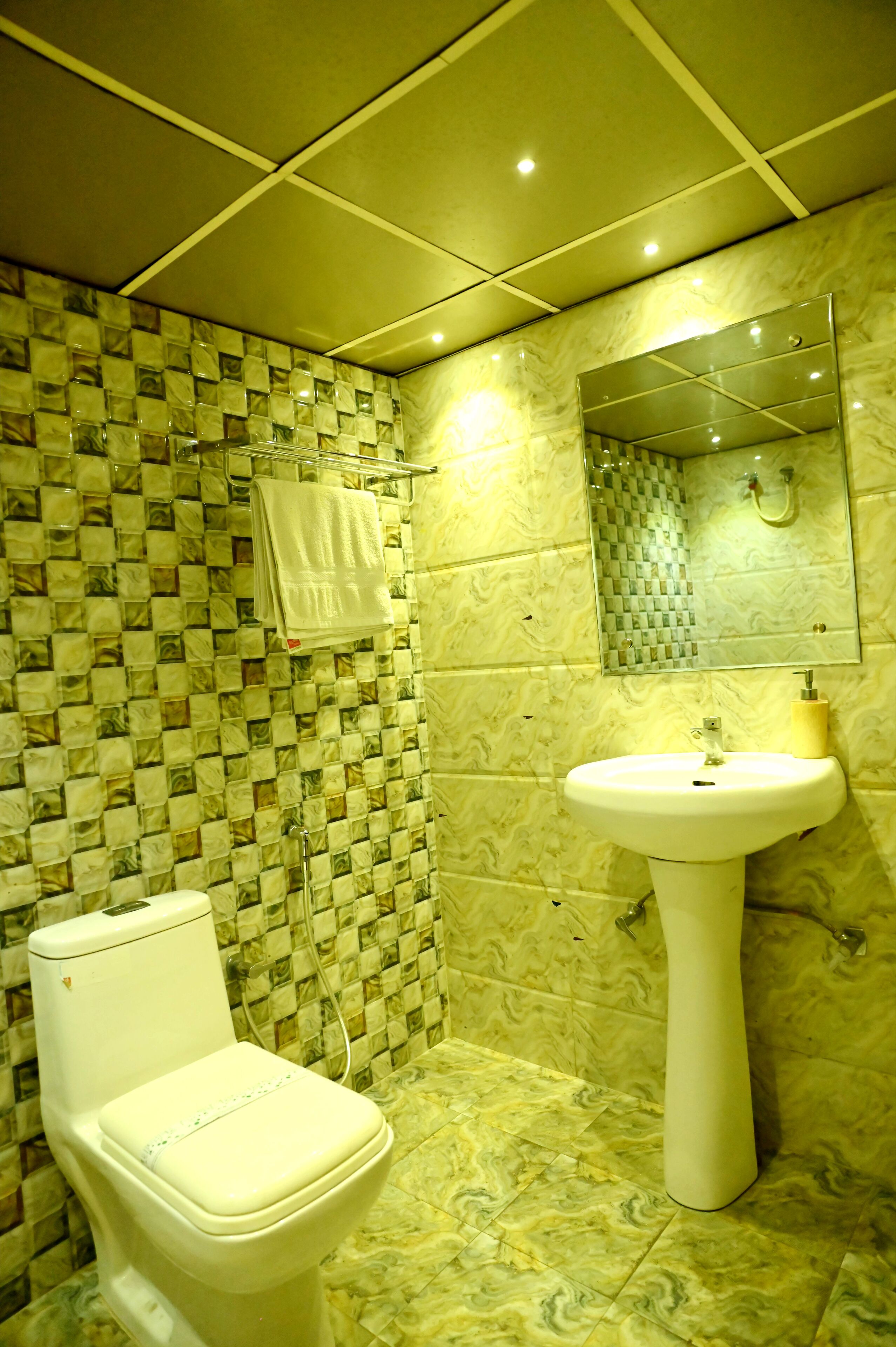 A bathroom with a toilet, sink, and mirror.