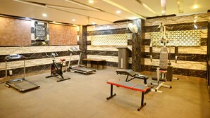 A gym with treadmills, an elliptical, a bench, and weightlifting equipment. - Citi Club (Kanpur)