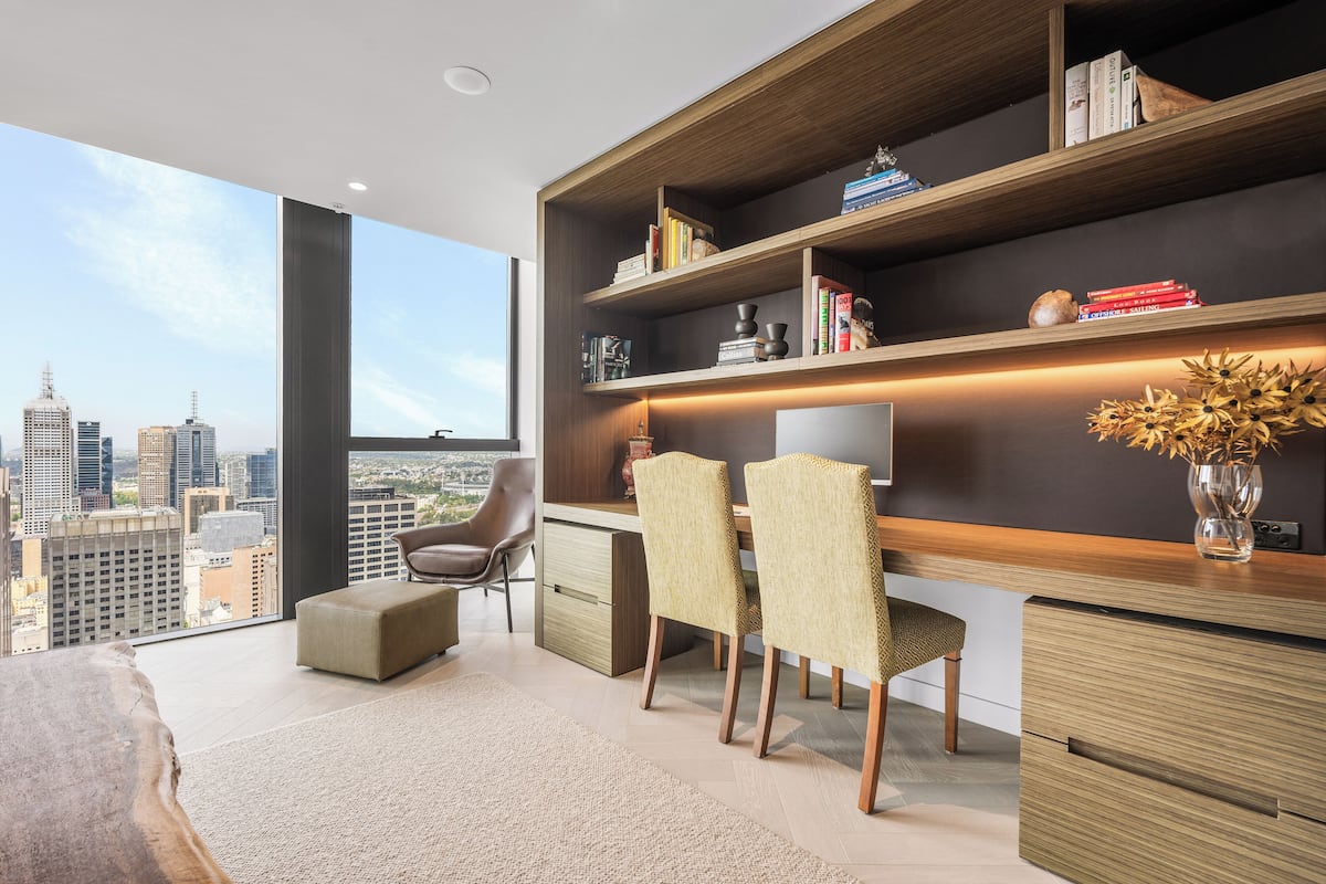 A modern office space with a desk, chairs, and a bookshelf.