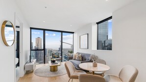 Un salon moderne avec une grande fenêtre, une table à manger ronde et un canapé.