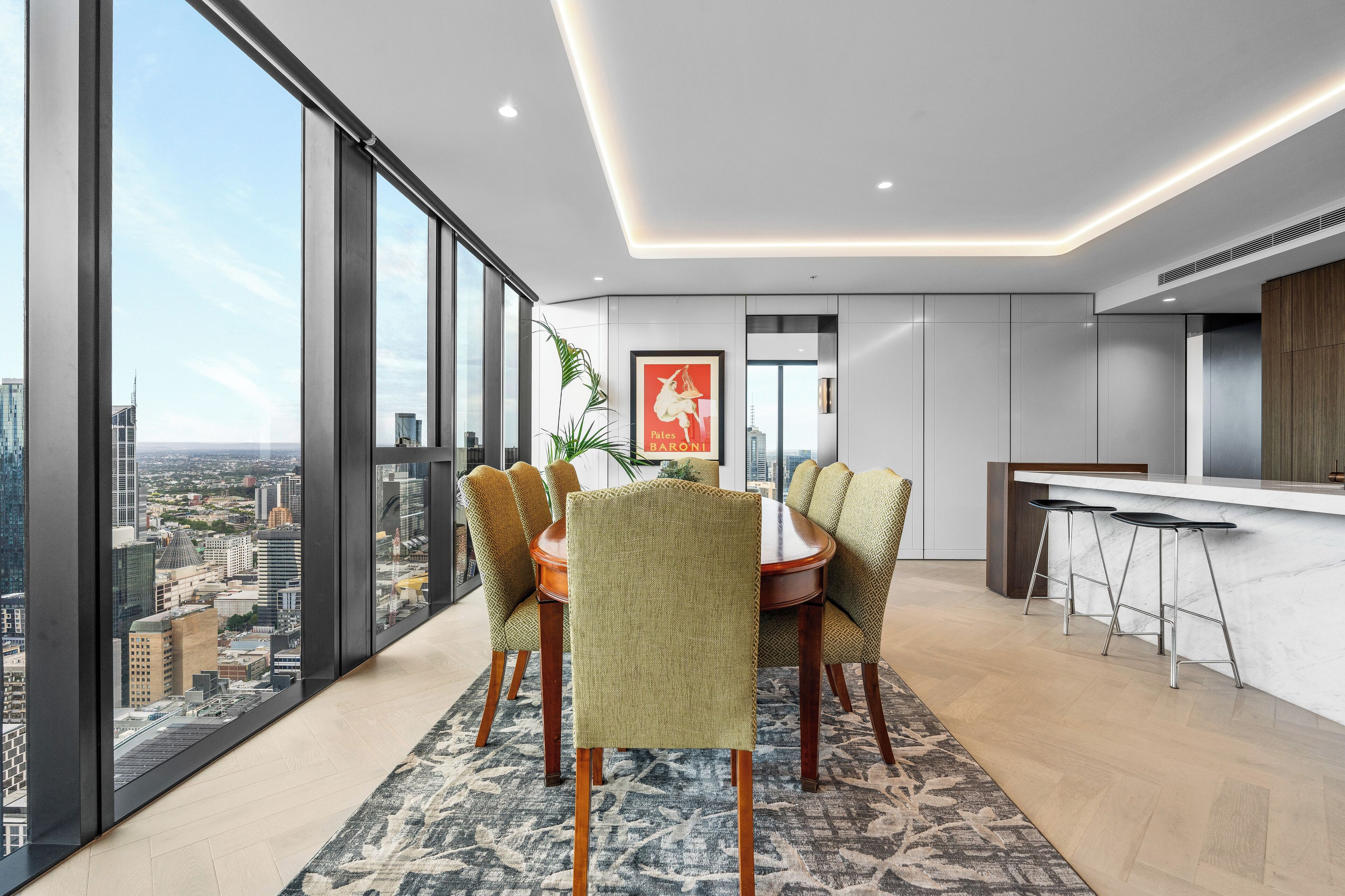 A modern dining area with a city view, a large window, and a bar area.