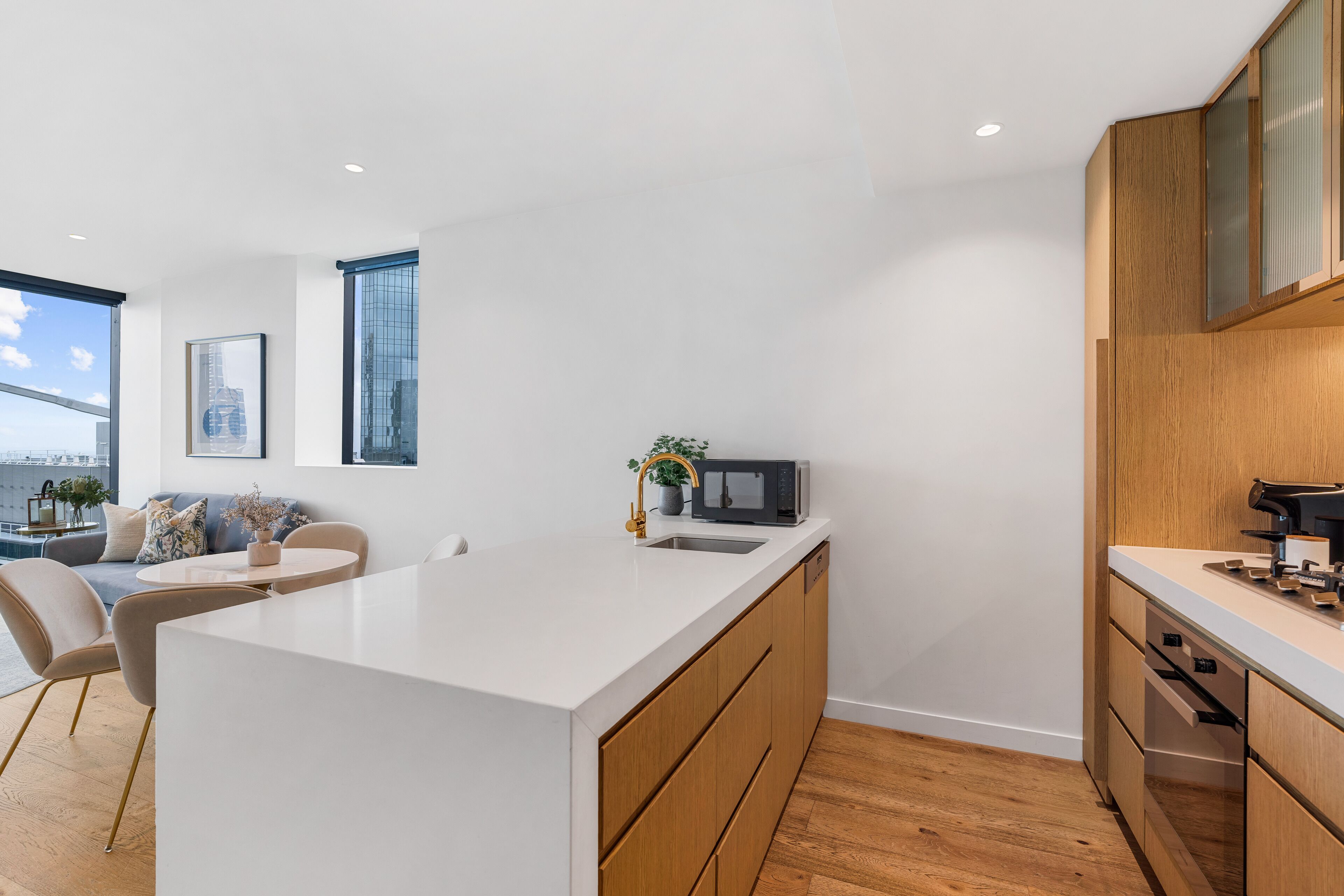 Una cocina moderna con una isla central, armarios de madera y vistas a la ciudad.