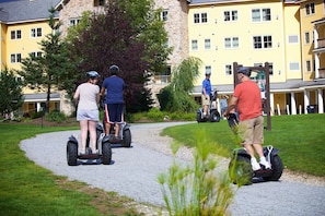 Explore the serene surroundings of this residential area, where a scenic path invites you to ride a Segway through well-manicured lawns and beneath the shade of trees.