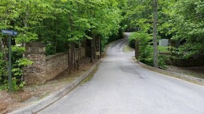 A road named 'Tibberwinds Way' surrounded by lush greenery and stone walls. - Blessed Nest 1 Bedroom Cabin by RedAwning (Townsend)
