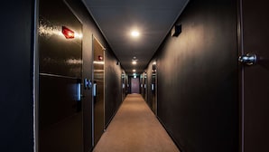A long, narrow hallway with doors on both sides, leading to individual rooms. - Dodubong Stay Hotel (Jeju City)