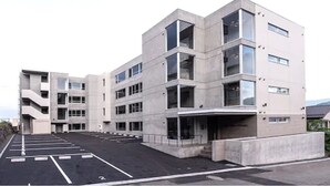 A modern multi-story building with a parking lot in front. - Stay's OTARU (Otaru)