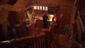 A wooden cabin interior with a kitchen area, wooden walls, and a staircase. - Stunning Cabin w/360º view of Guatemala Highlands (Tecpán Guatemala)