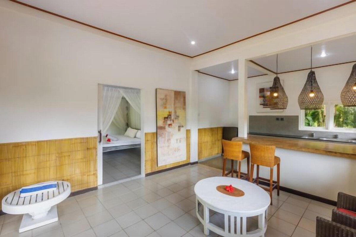 A modern room with a dining area, a kitchen, and a sleeping area.
