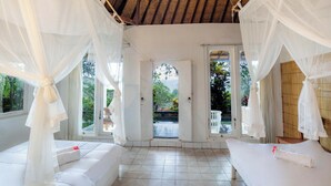 A room with a bed, white curtains, and a view of the outdoors. - Taman Indrakila (Ubud)
