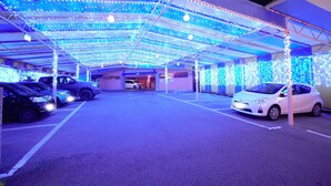 A parking garage with multiple cars parked under a canopy of blue and white lights. - Hotel LaLa PAT1 - Adults Only (Sakai)