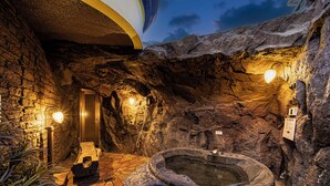 A spa area with a hot tub, stone walls, and a door leading to another room. - Hotel LaLa PAT1 - Adults Only (Sakai)