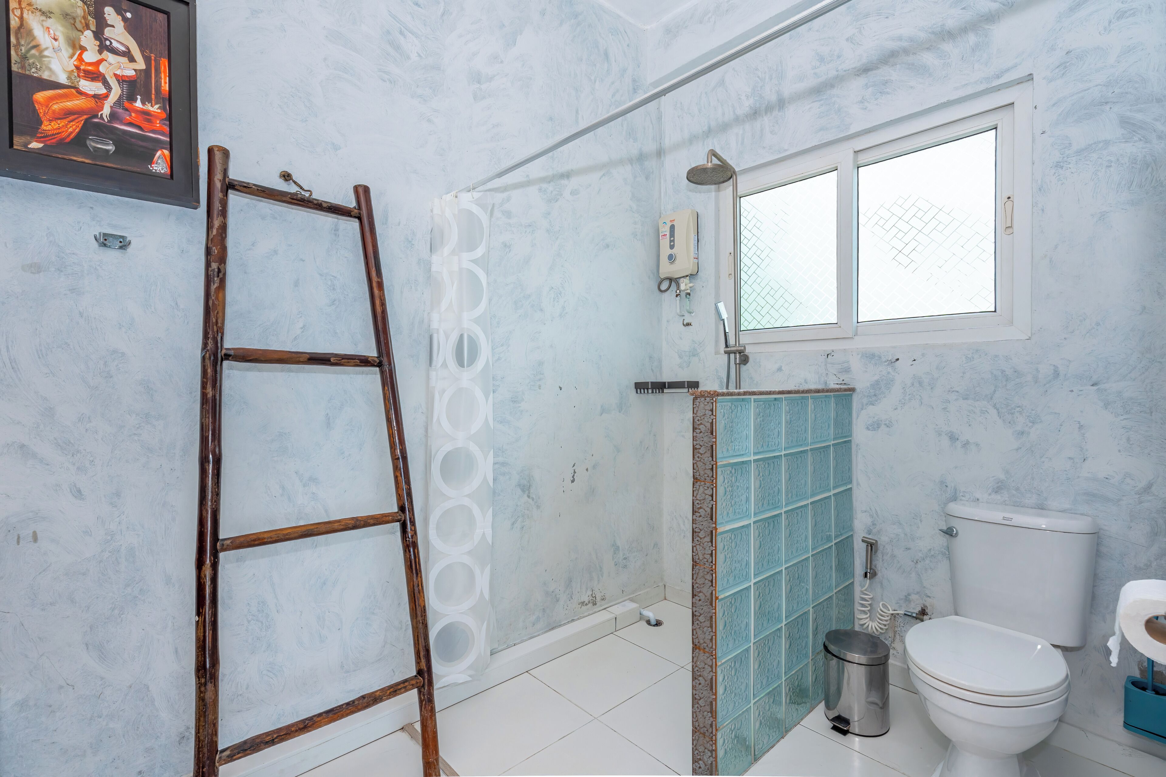 A bathroom with a shower, toilet, and a window.