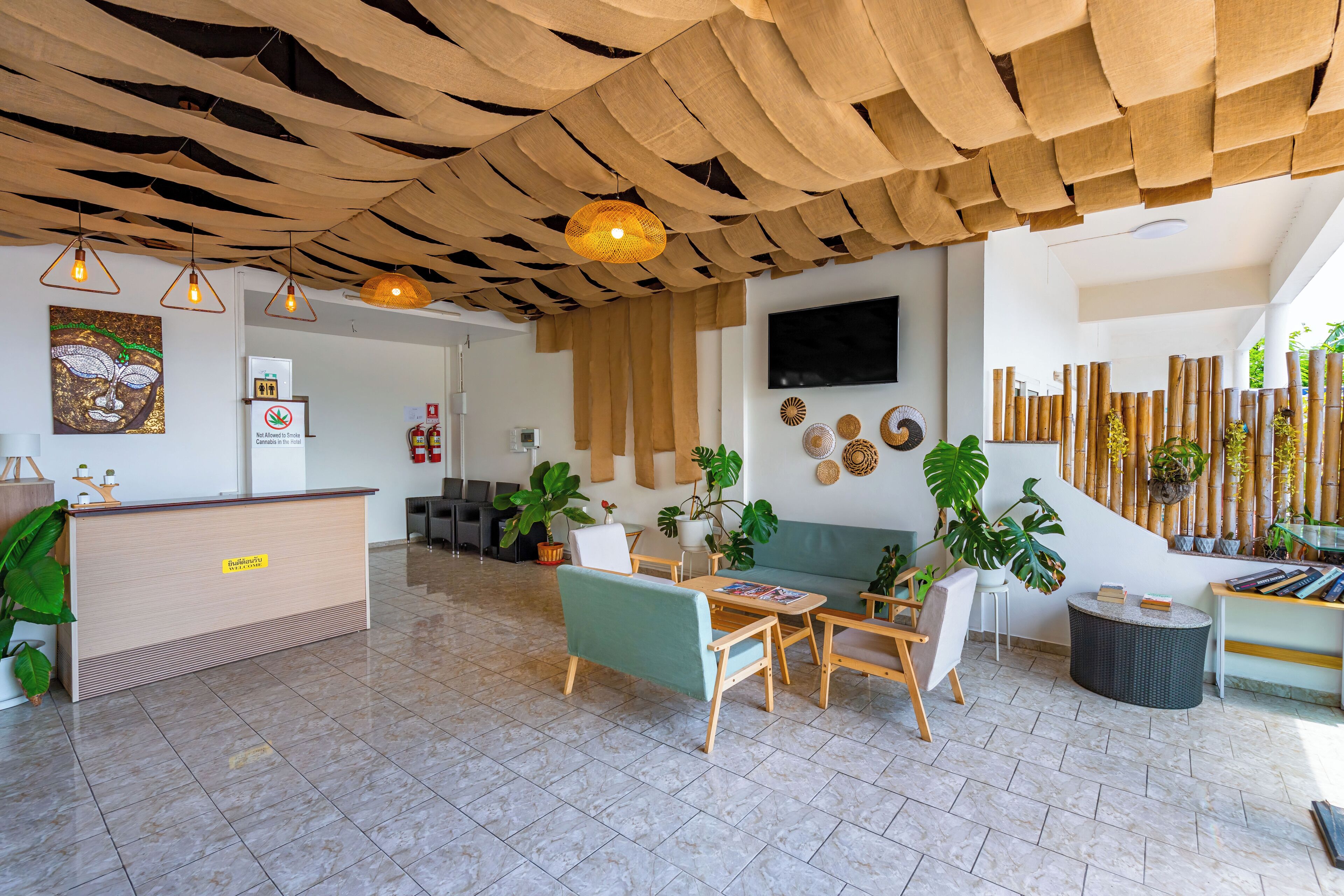 A modern reception area with a wooden reception desk, seating arrangements, and a large TV screen.