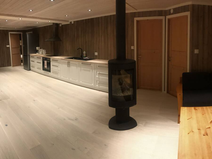 Een moderne keuken met een centraal eiland, houten kastjes en een ingebouwde kookplaat.