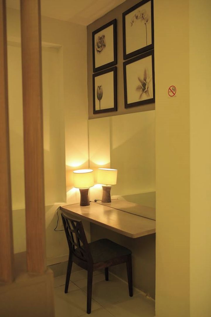 A dining area with a table, two chairs, and two wall-mounted lamps.