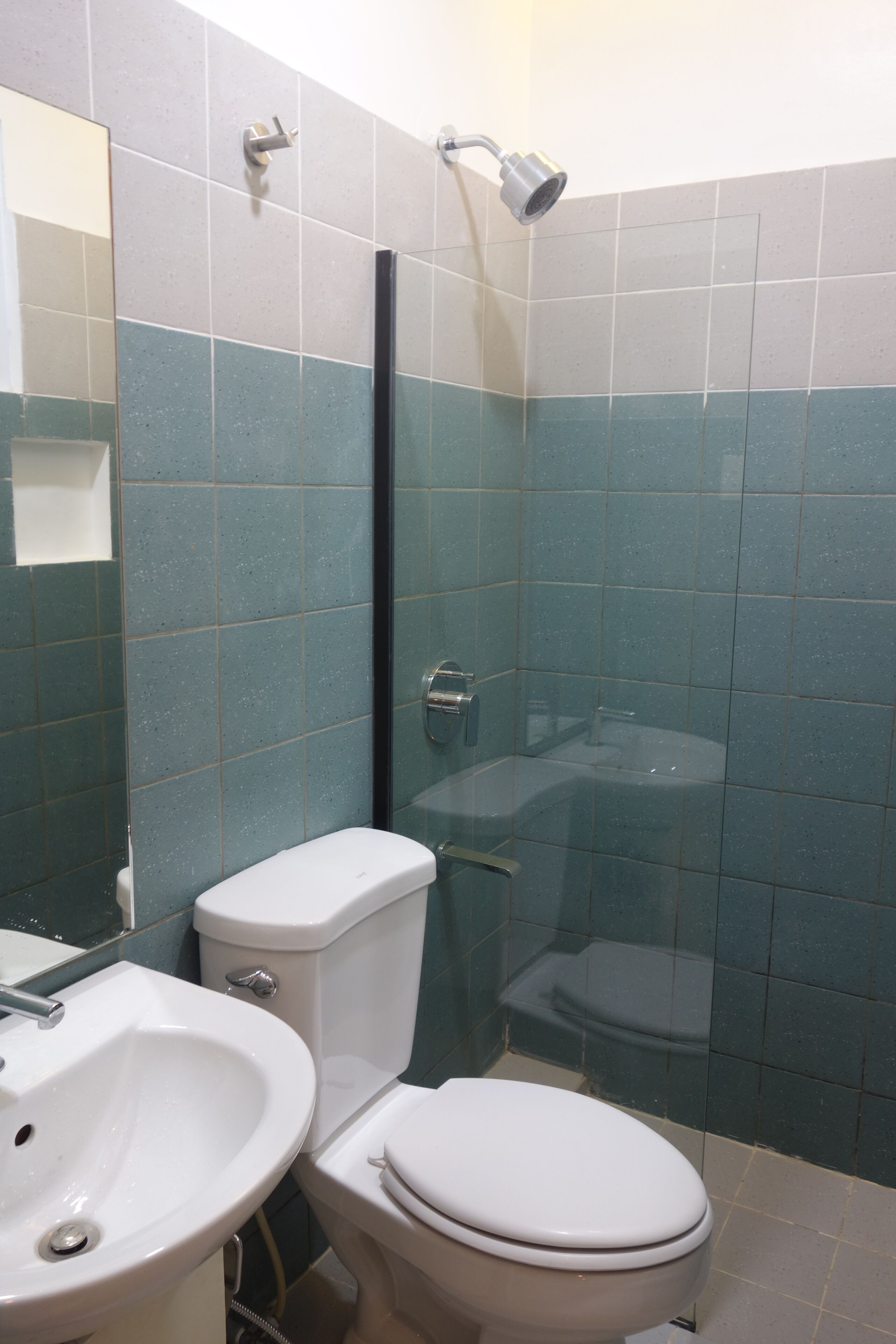 A bathroom with a toilet, sink, and shower.