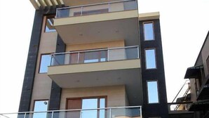 A multi-story building with balconies and large windows.