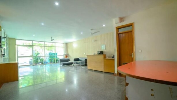 A spacious lobby with a reception desk, seating area, and large windows.