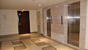 Un área de ascensores moderna con dos ascensores y una puerta.