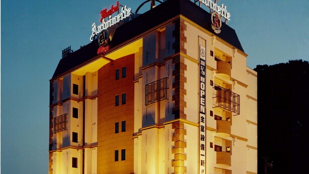 Un hotel de estilo arquitectónico clásico, con varios balcones y un letrero llamativo en el techo.