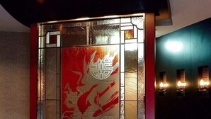 Un vestíbulo con una pared decorativa que muestra diseños tradicionales y una planta en maceta.