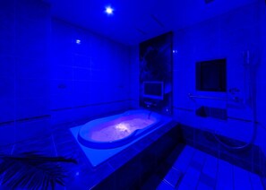 A modern bathroom with a large bathtub, a shower area, and a small sink. - Hotel Plant -garden Resort- Adult Only (Toyokawa)